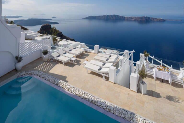 Pool terrace with white loungers on the cliff edge at Above Blue Suites, Imerovigli, Santorini