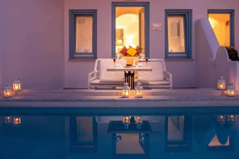 Candlelit table beside a plunge pool outside a suite at dusk at Above Blue Suites, Imerovigli, Santorini