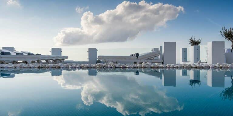 Infinity pool reflecting the sky over the caldera at Above Blue Suites, Imerovigli, Santorini