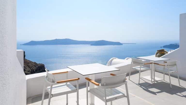 Terrace with a dining table and chairs facing the caldera at Astra Suites, Imerovigli, Santorini