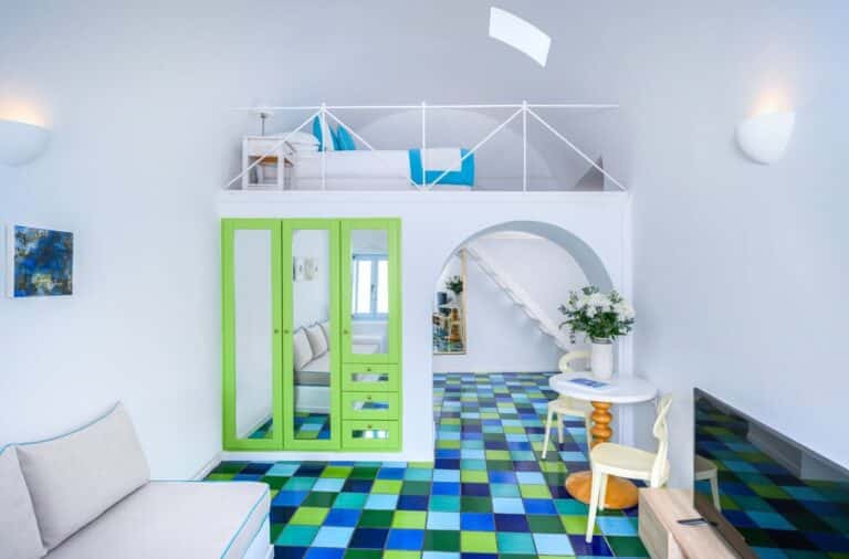 Split-level suite with a sleeping loft and colourful tiled floor at Astra Suites, Imerovigli, Santorini