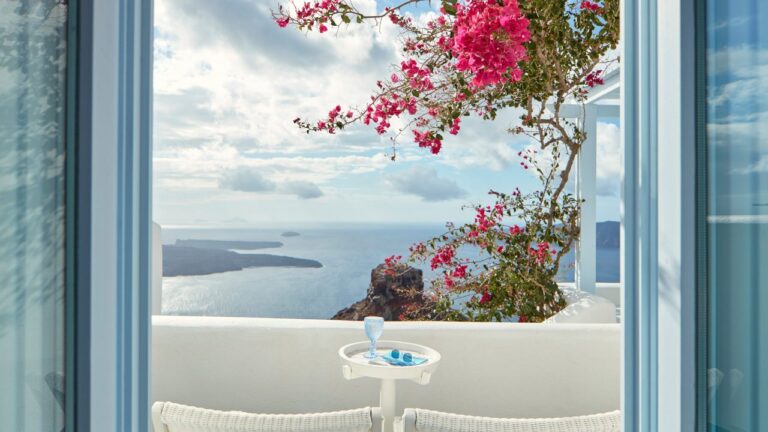 Bougainvillea framing the doorway onto a caldera-view terrace at Astra Suites, Imerovigli, Santorini