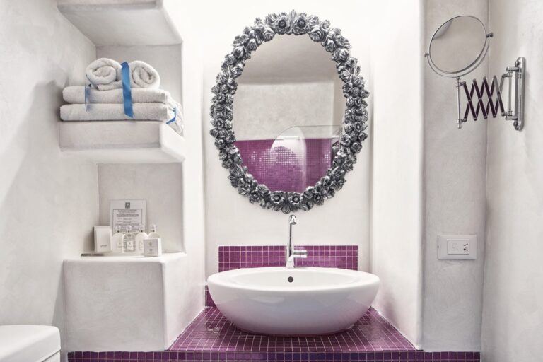 Bathroom with a basin and ornate mirror at Astra Suites, Imerovigli, Santorini
