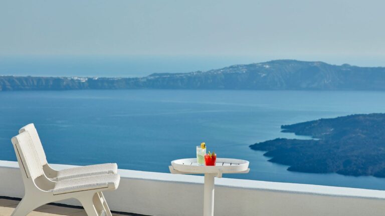 Lounge chair and side table on a terrace overlooking the caldera at Astra Suites, Imerovigli, Santorini