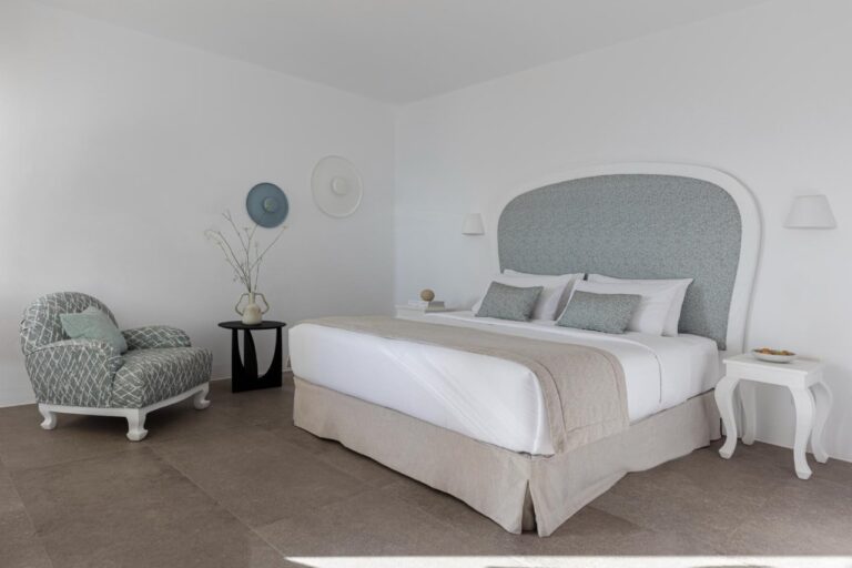 Bedroom with a double bed and upholstered headboard at Canaves Oia Suites, Oia, Santorini