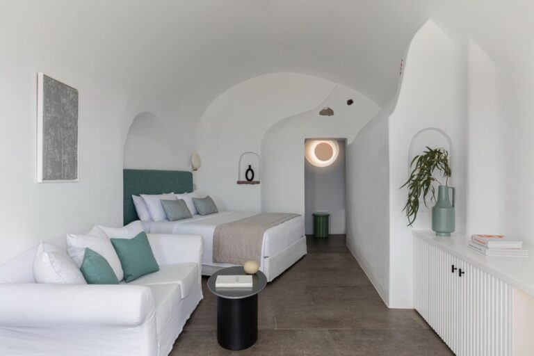 Cave suite with a sofa, bed and arched alcoves at Canaves Oia Suites, Oia, Santorini