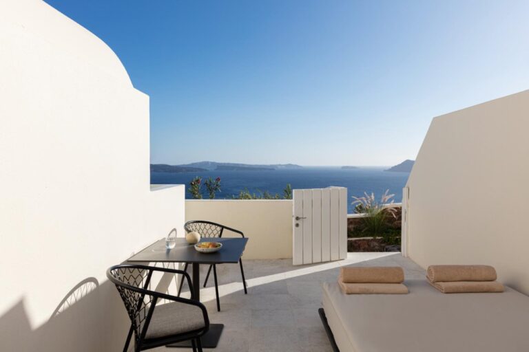 Terrace with a table, chairs and loungers facing the caldera at Canaves Oia Suites, Oia, Santorini