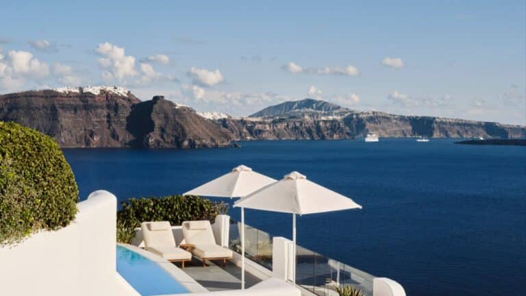Pool terrace with parasols and views across the caldera at Canaves Sunday, Oia, Santorini