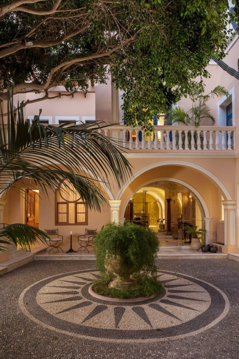 Courtyard with a pebble mosaic floor and arched loggia at Casa Delfino, Chania, Crete