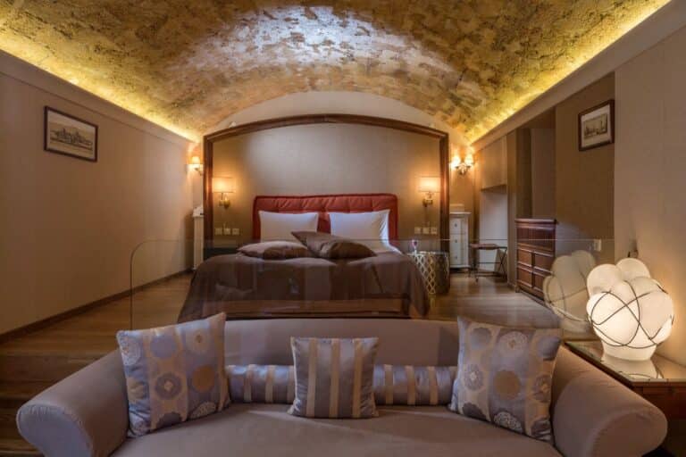 Suite with a vaulted stone ceiling and sitting area at Casa Delfino, Chania, Crete
