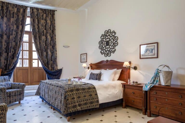 Bedroom with tall windows and patterned curtains at Casa Delfino, Chania, Crete