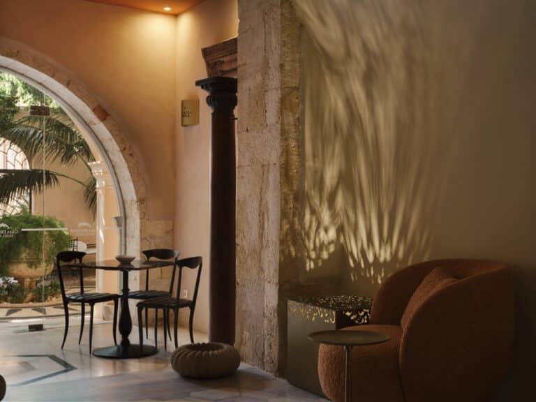 Lounge with a stone arch and armchairs at Casa Delfino, Chania, Crete