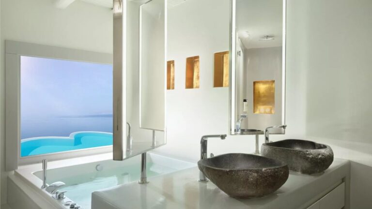 Bathroom with twin stone basins and a soaking tub at Cavo Tagoo, Mykonos