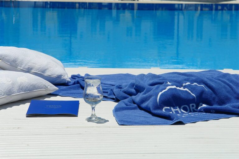 Poolside towel and glass beside the blue pool at Chora Resort Hotel & Spa, Folegandros