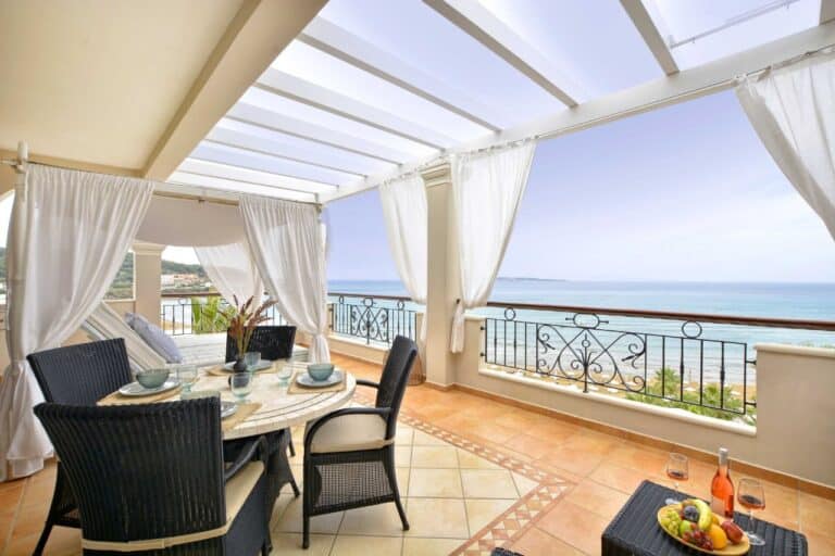 Covered terrace with a dining table and sea views at Delfino Blu Wellness Boutique Hotel, Agios Stefanos, Corfu