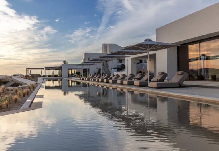 Main pool reflecting the hotel and sky at Domes White Coast, Mytakas, Milos
