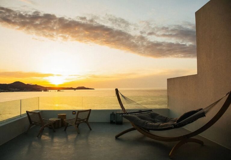 Terrace with a hammock chair at sunset at Domes White Coast, Mytakas, Milos