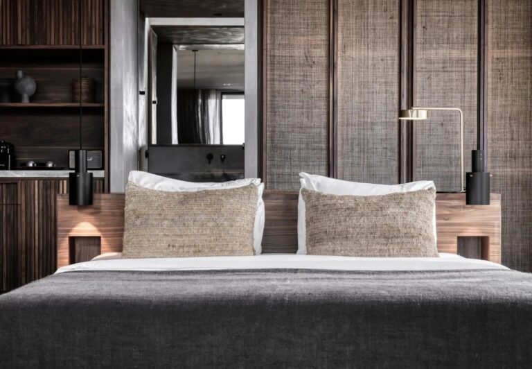 Bedroom with timber panelling and a grey headboard at Domes Zeen Chania, Crete
