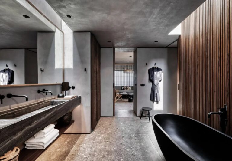 Bathroom with a black freestanding tub and stone basin at Domes Zeen Chania, Crete