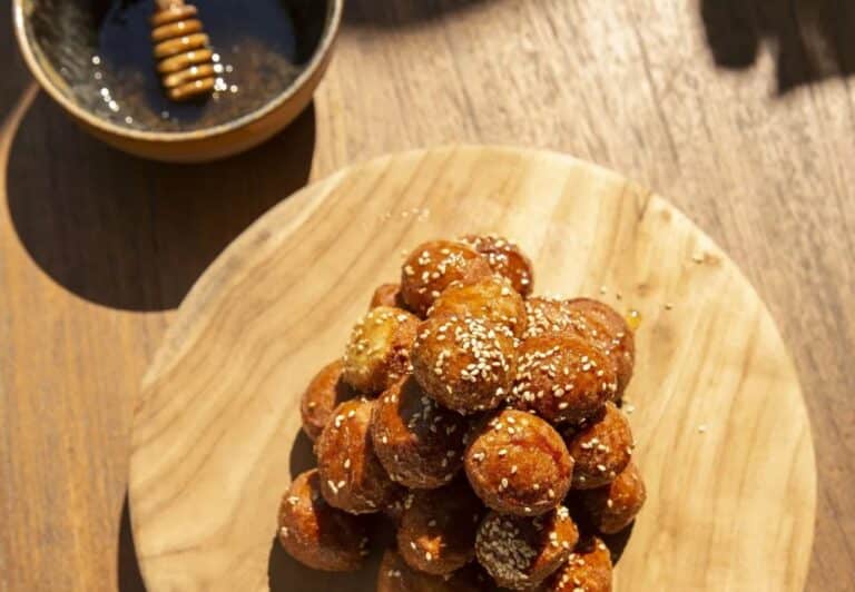 Honey-glazed loukoumades on a wooden board at Domes Zeen Chania, Crete