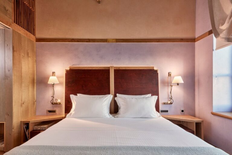 Bedroom with a wooden headboard and bedside lamps at Domus Renier, Chania, Crete
