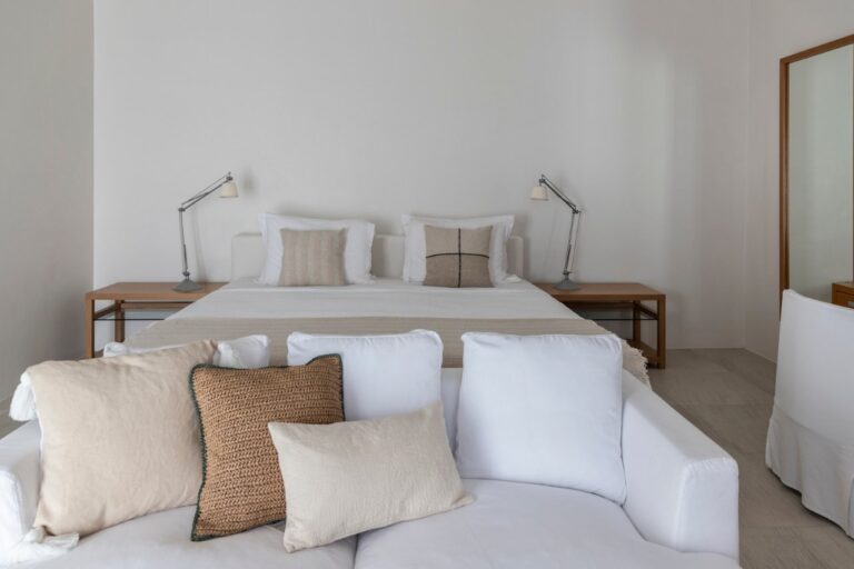 Bedroom with white linen and bedside lamps at Elies Resorts, Vathi, Sifnos