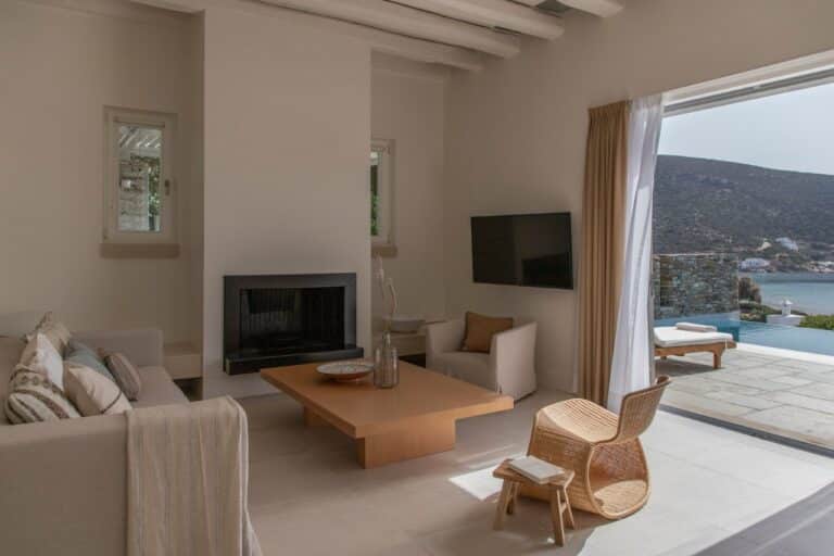 Living room with a fireplace and views of the bay at Elies Resorts, Vathi, Sifnos