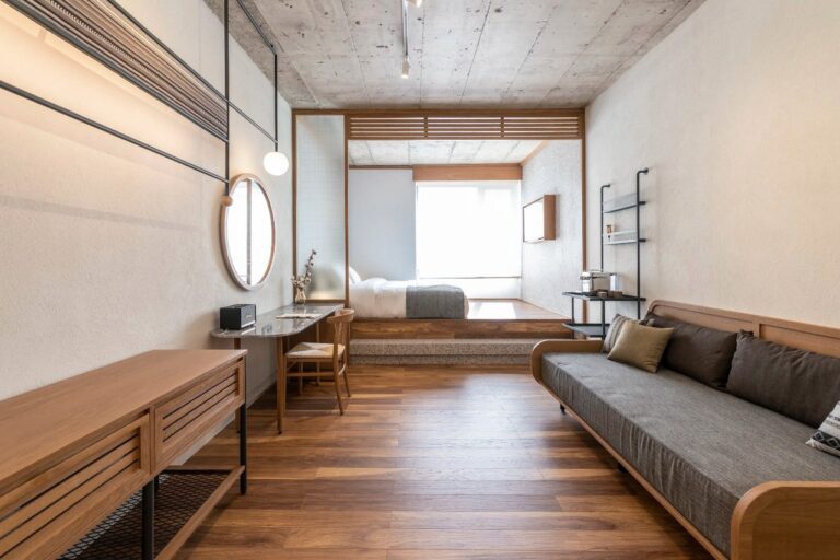 Room with a long sofa, desk and timber floors at Ergon House, Athens