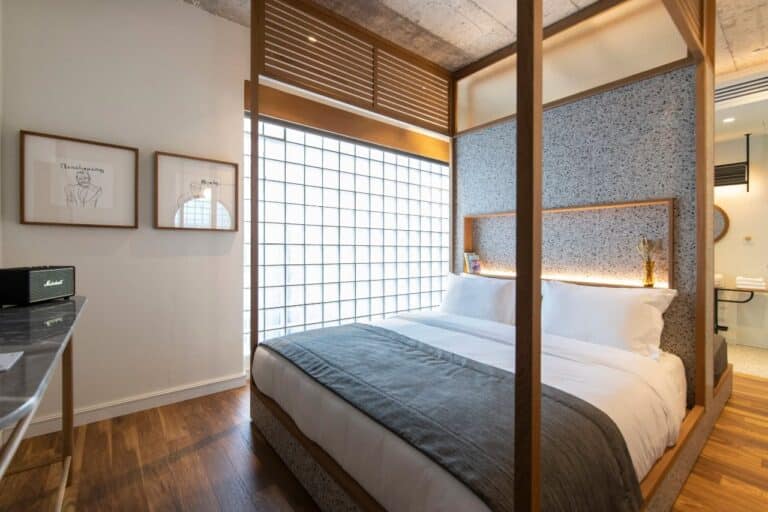 Bedroom with a glass-brick wall and wooden screens at Ergon House, Athens
