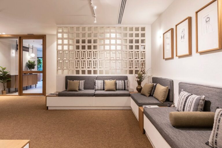 Lounge with built-in banquettes and framed prints at Ergon House, Athens