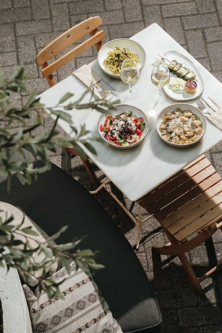 Table of Greek dishes and wine on a terrace at Ergon House, Athens